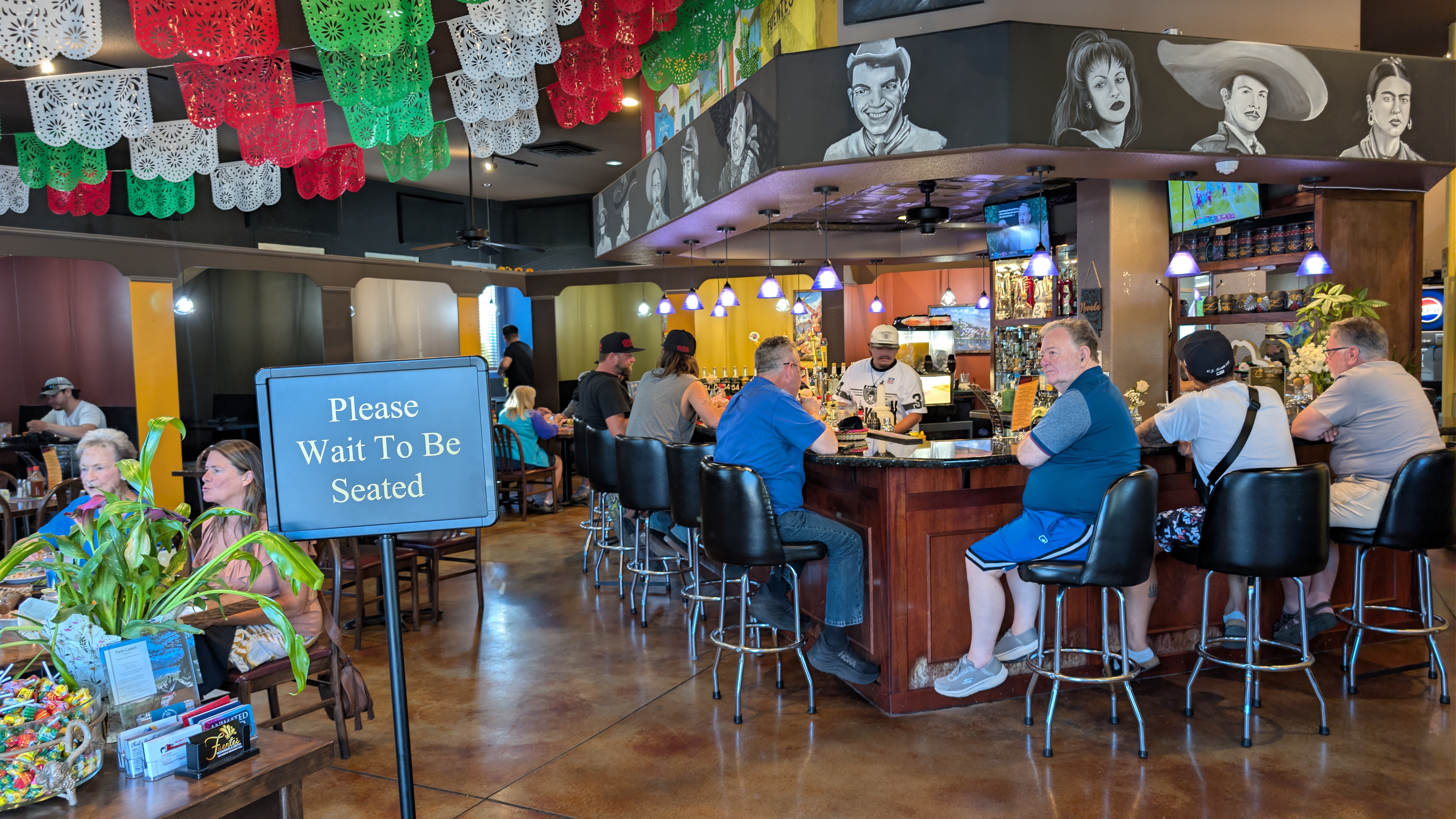 A cantina table with Mexican dishes, chips, and a margarita.